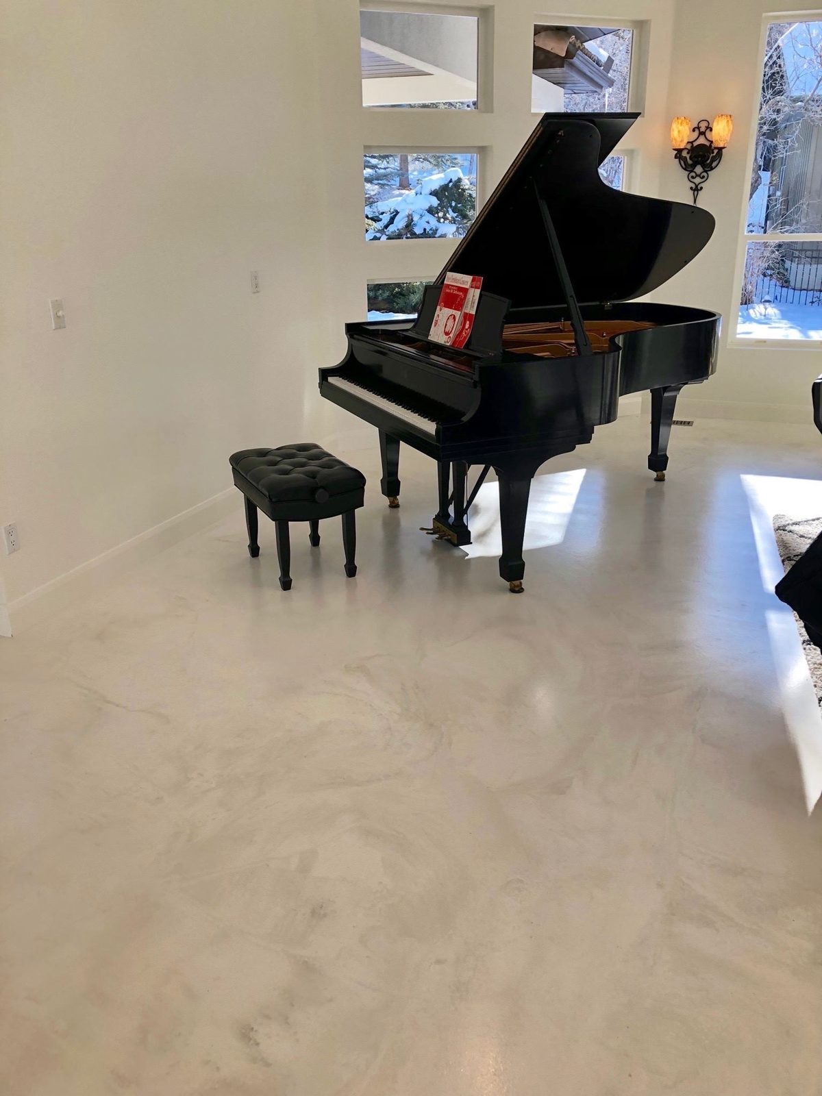 Jointless marble-look microcement floor in a Nashville living room with grand piano — 2,843 sq ft